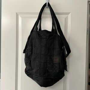 Back leather tote handbag with handles and shoulder strap.